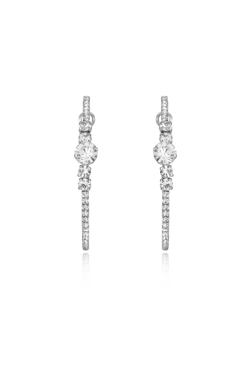 A pair of large silver-toned hoop earrings featuring clear crystals stones