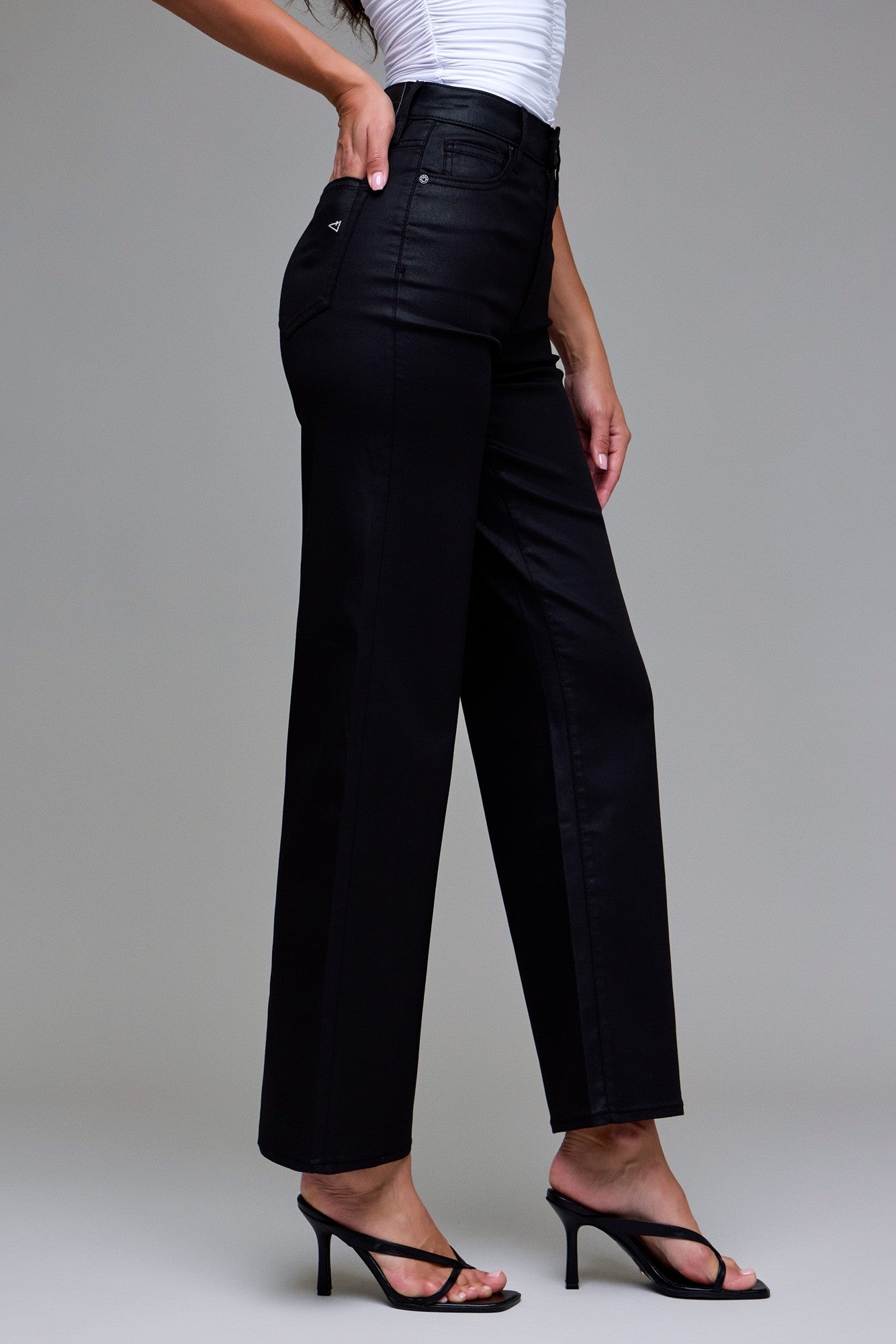 Close-up of black coated denim fabric on the Abby wide-leg jeans showing the sleek, waxy texture.