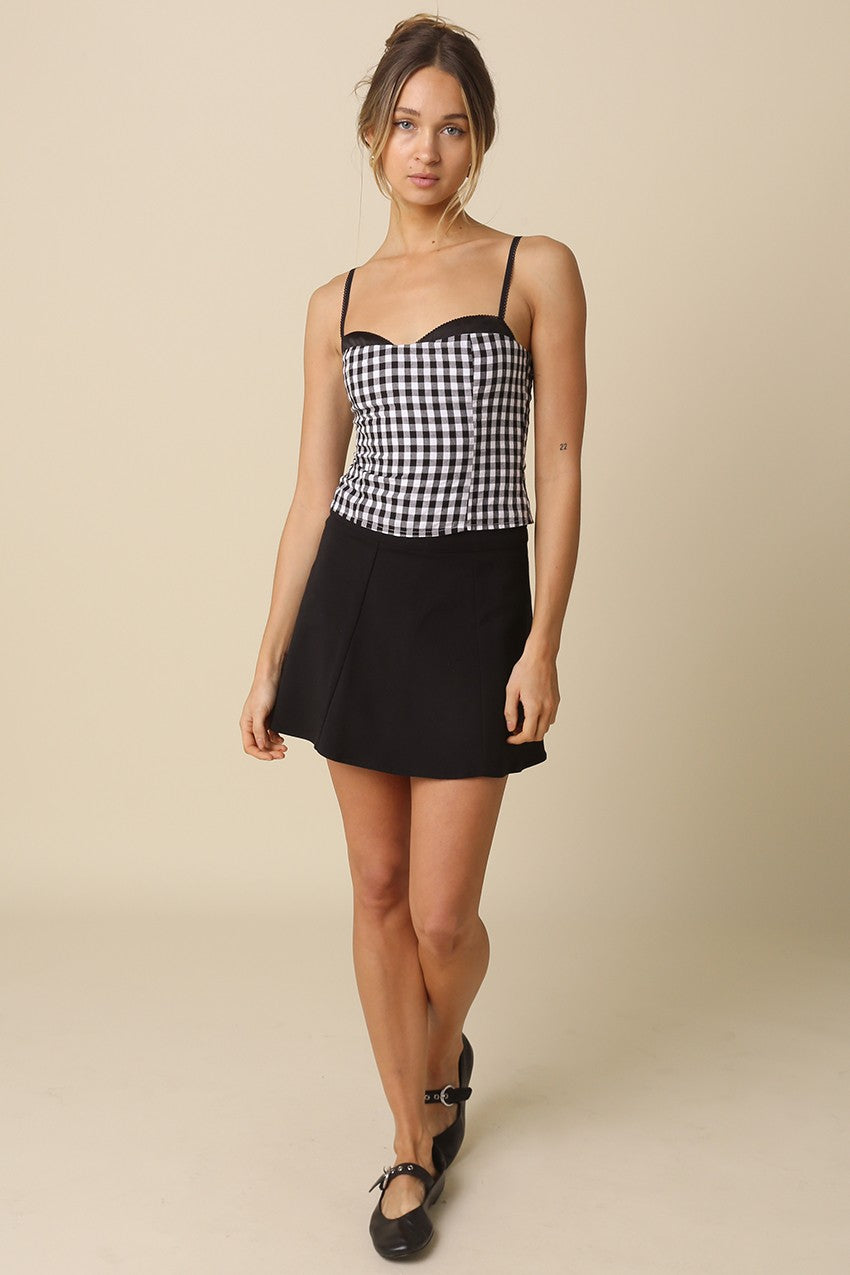 Model wearing a black and white gingham bustier top for a trendy date night outfit in Hoboken.