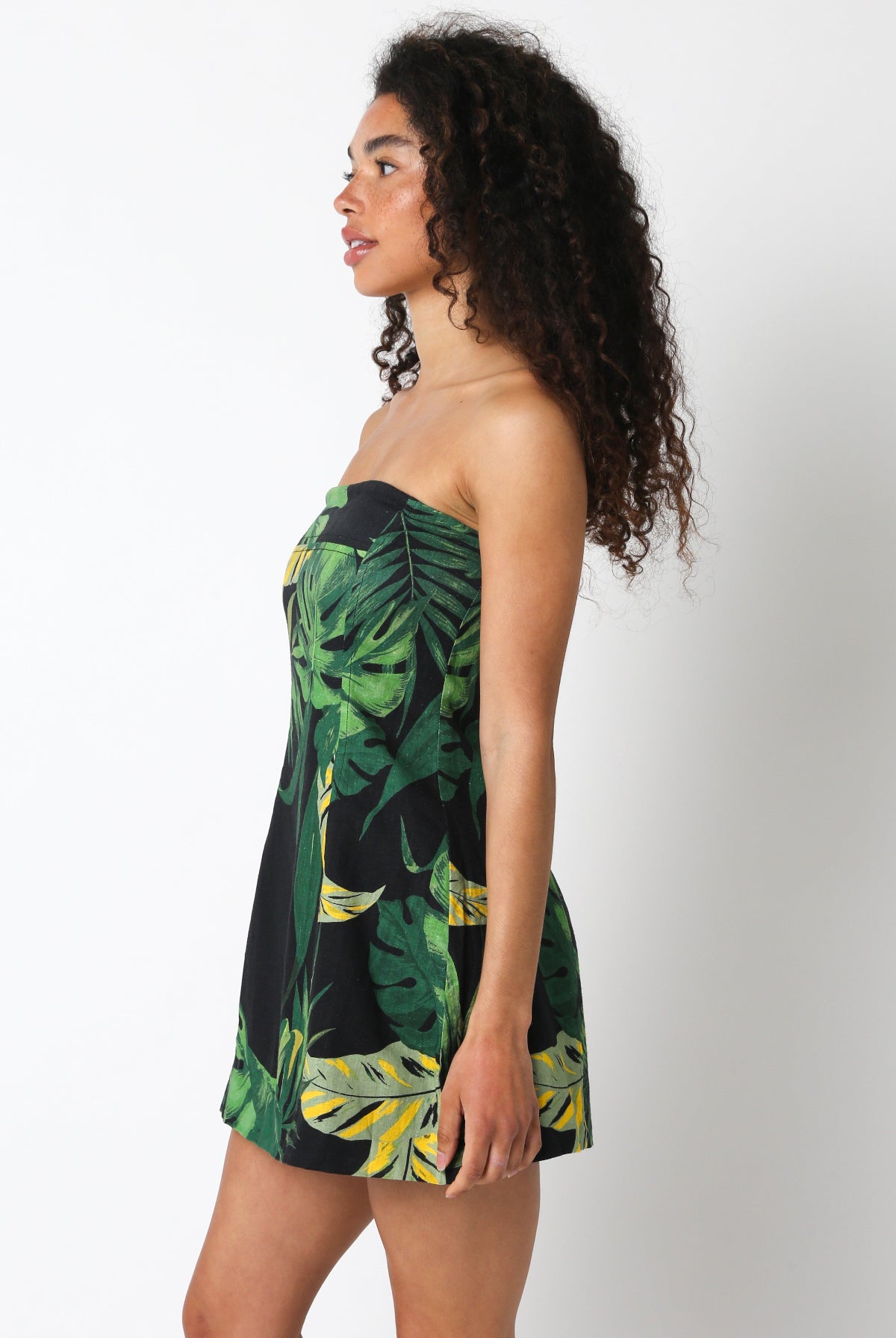 Side profile of the black palm print fit-and-flare mini dress with structured bodice