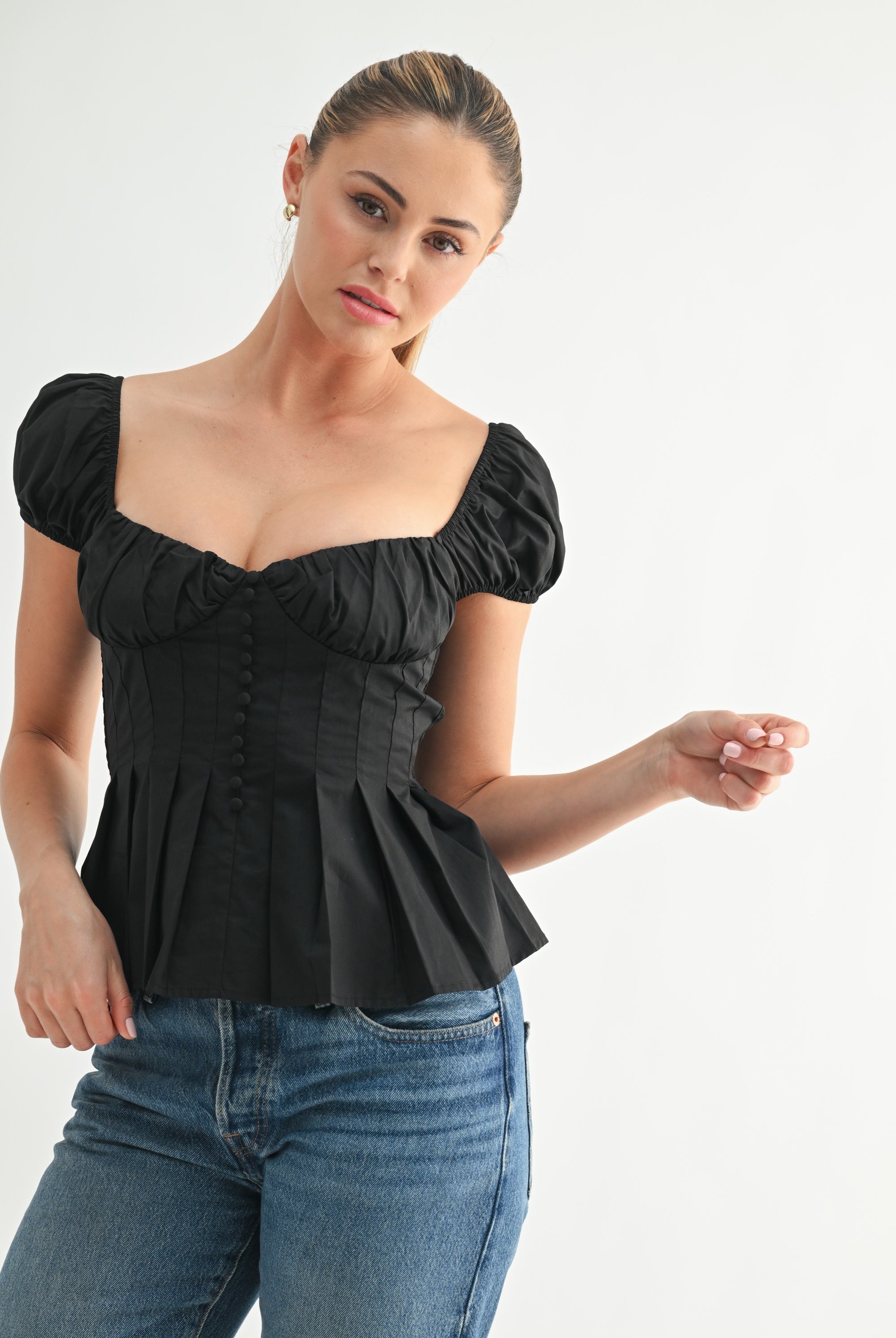 Model wearing black puff sleeve top off the shoulder