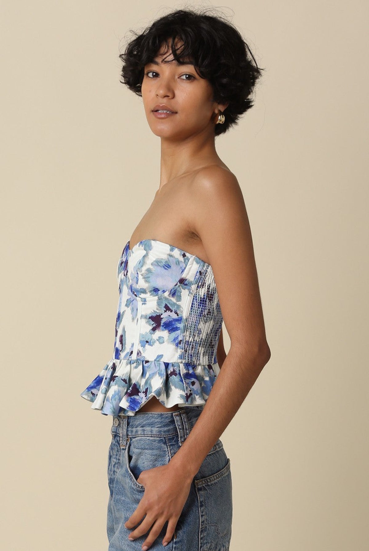 Side profile of the Dani corset top highlighting the structured boning and flared ruffle peplum