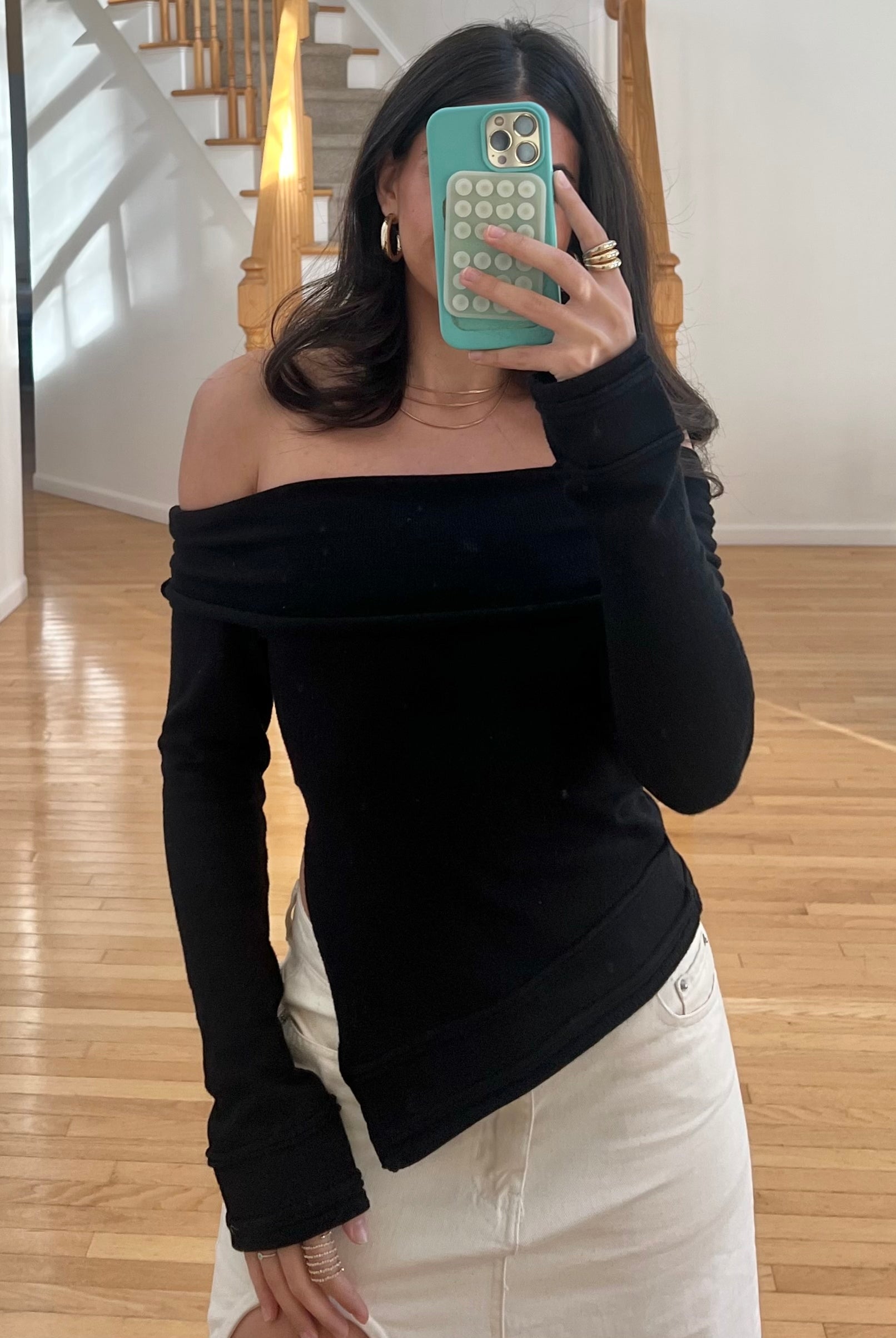 Black asymmetric off-the-shoulder long sleeve top in a cashmere blend knit.