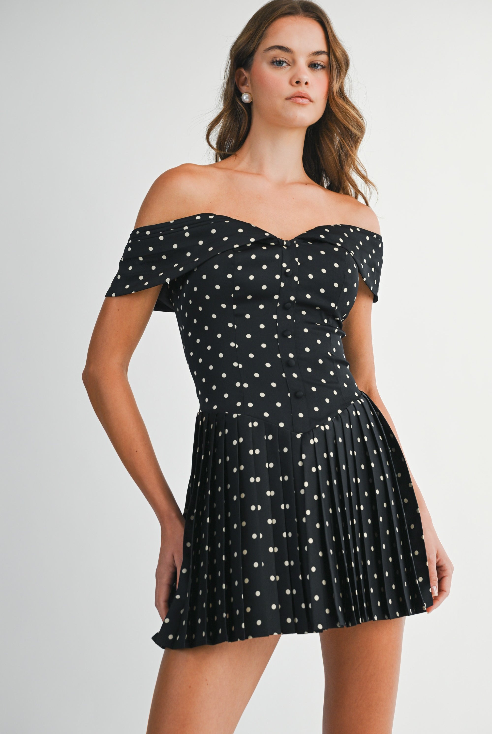 Front view of the Elyse black and white polka dot off-the-shoulder mini dress