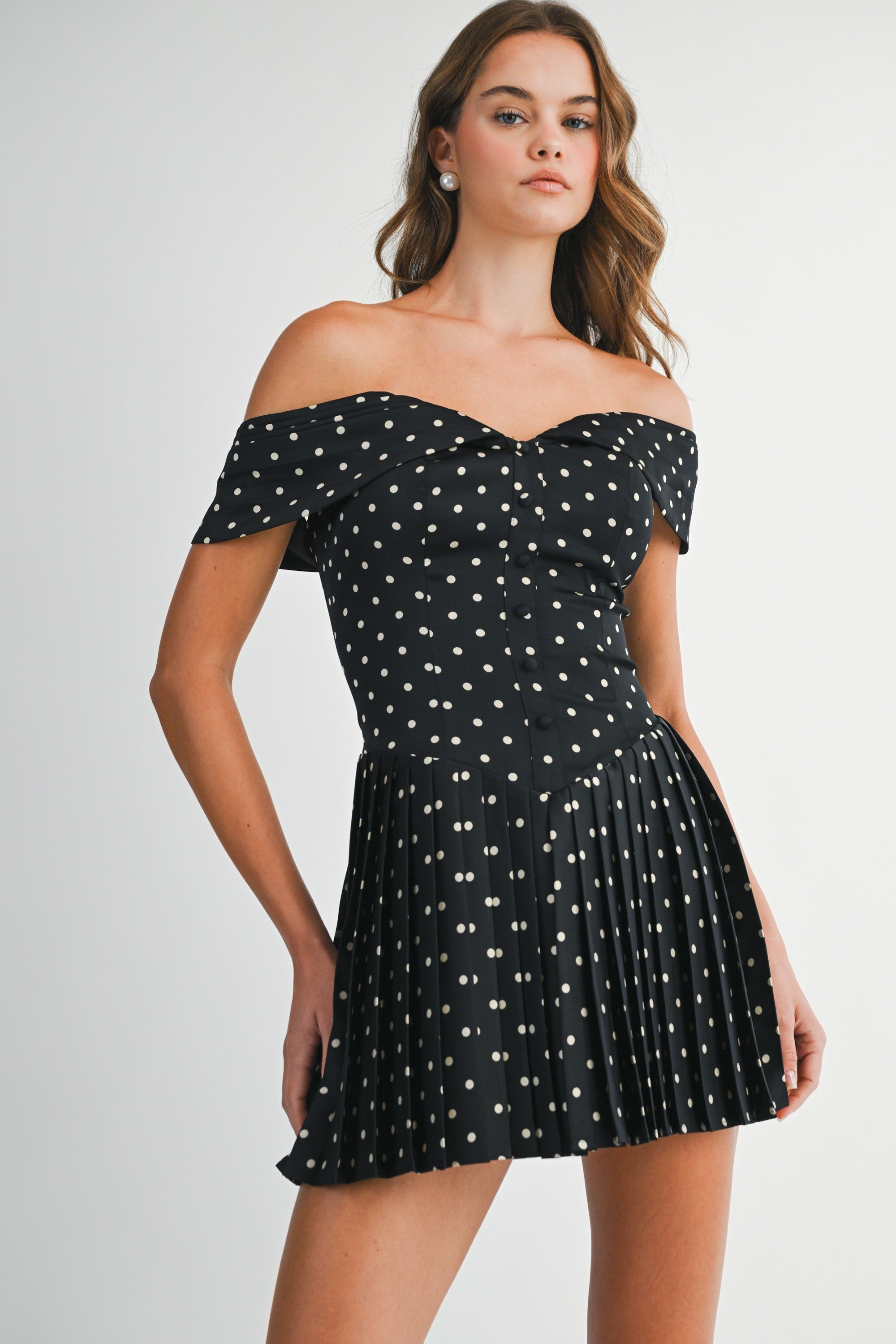 Front view of the Elyse black and white polka dot off-the-shoulder mini dress