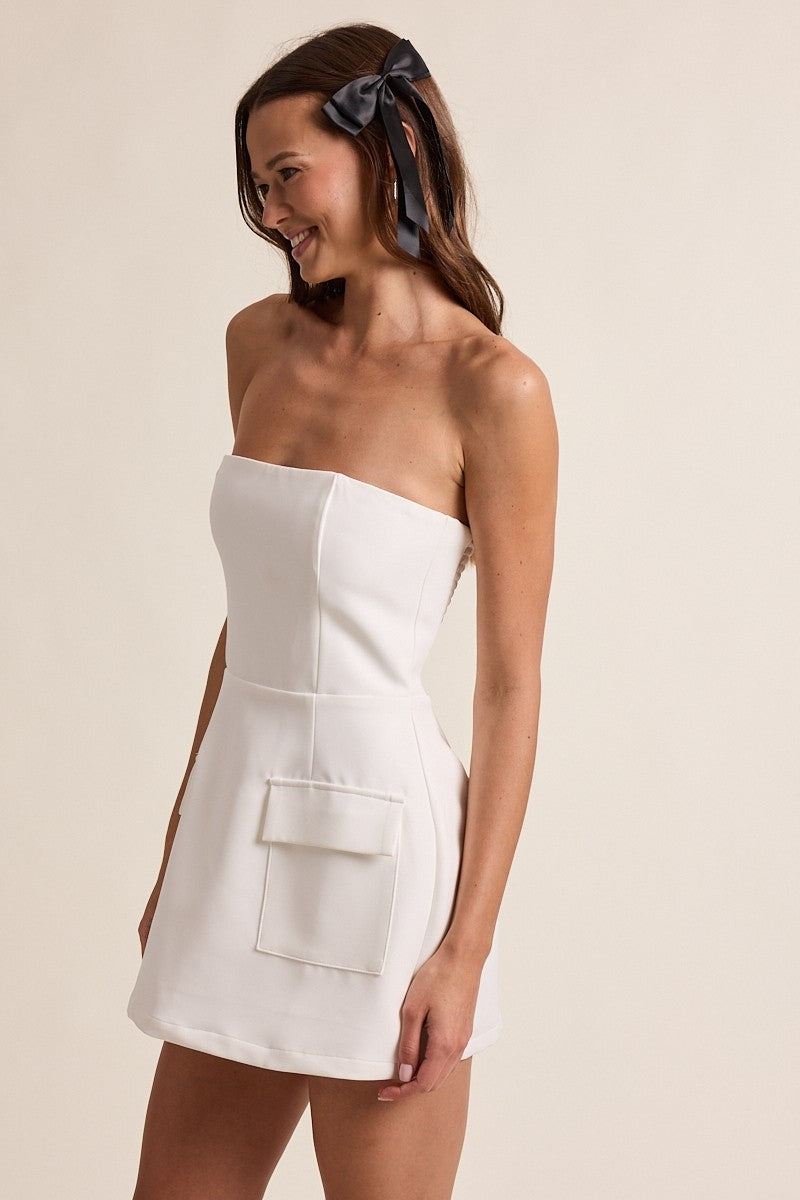 Side view of white A-line mini dress showing functional pockets and hidden built-in shorts
