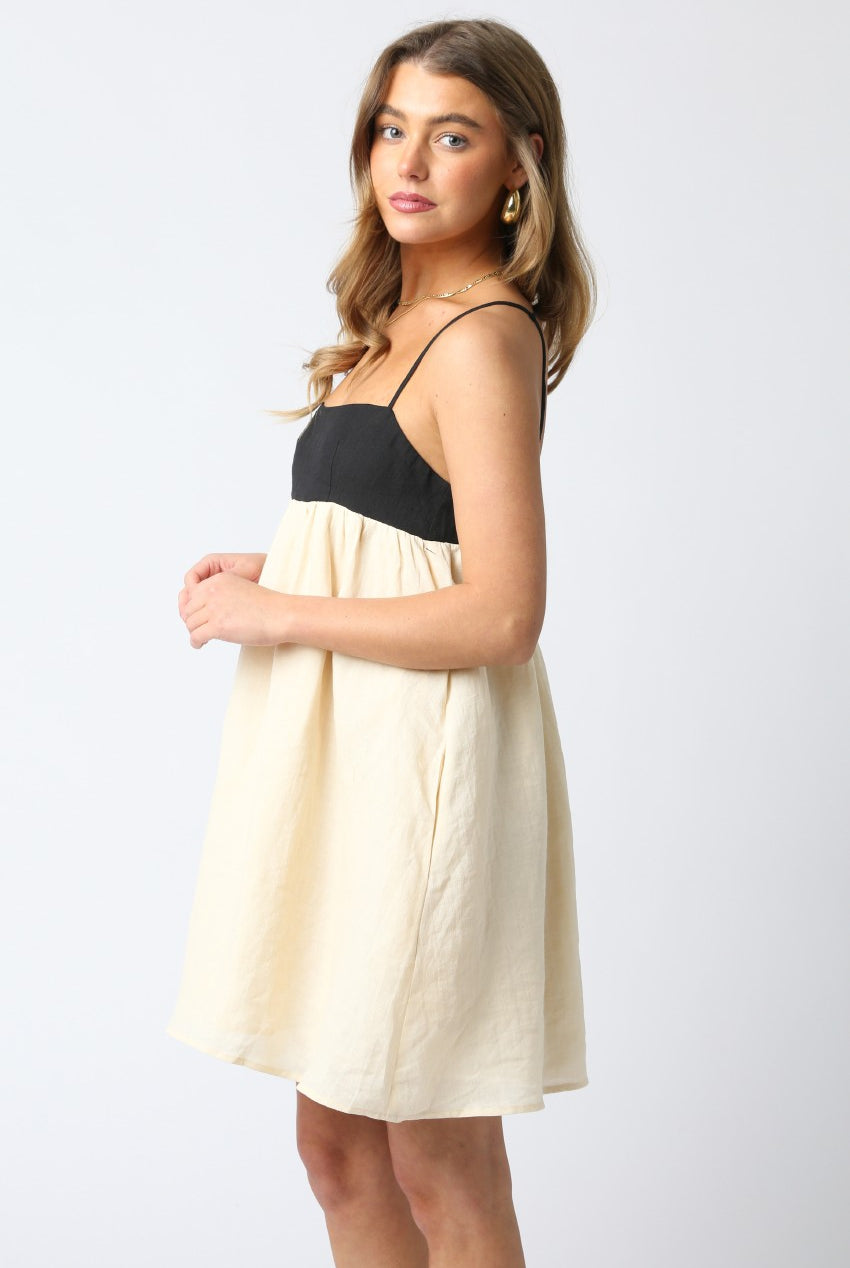 Model wearing a black and cream babydoll dress for sorority rush.