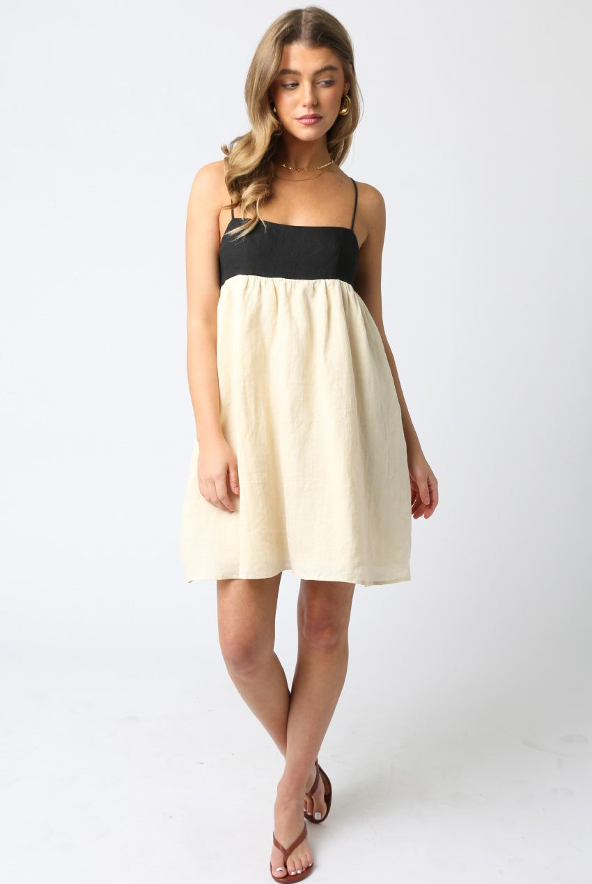 A chic black and cream babydoll dress styled with kitten heels for a date night