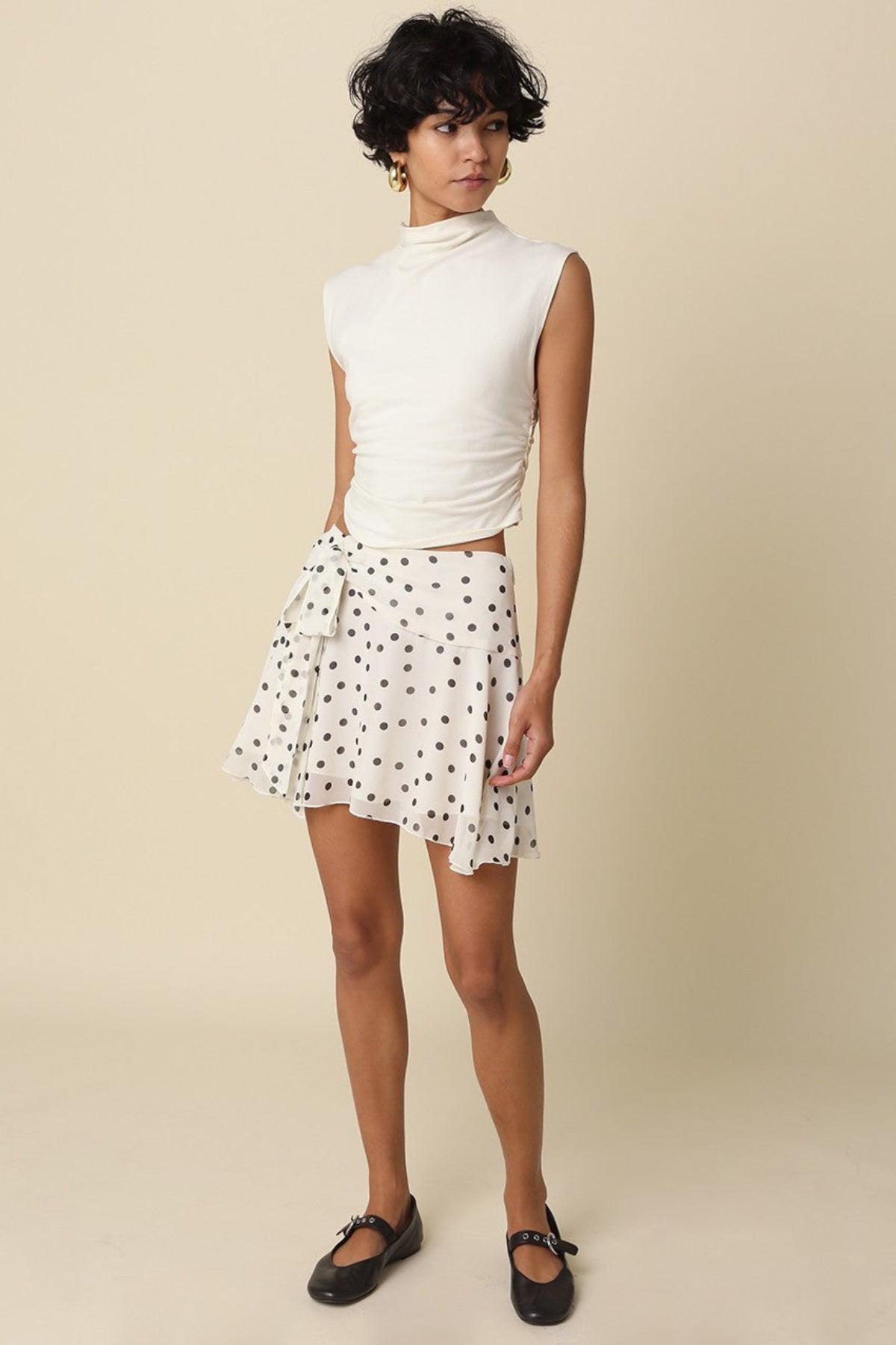 Full body styling of the white polka dot mini skirt with gold hoops and ballet flats