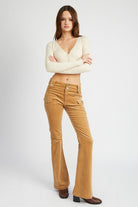 Model wearing Serafina khaki corduroy cargo flare pants with a fitted top and boots