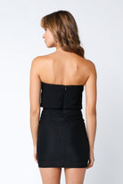 Back view of a black strapless bodycon dress with a hidden zipper closuree