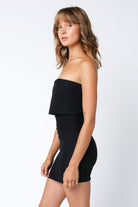 Side view of the Paula black mini dress highlighting the layered overlay detail