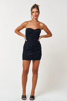 Model wearing the Midnight Kiss black glitter dress with a red lip for a party look