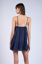 Back view navy blue mini dress for date night, styled as a flowy babydoll dress with adjustable straps.