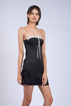 Flirty black mini dress for date night featuring a dainty ribbon accent.