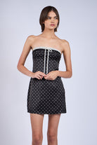 Detailed shot of black lace-trim neckline and ribbon on polka dot satin