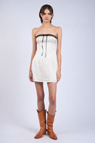 Model wearing ivory strapless party dress for birthdays or date night