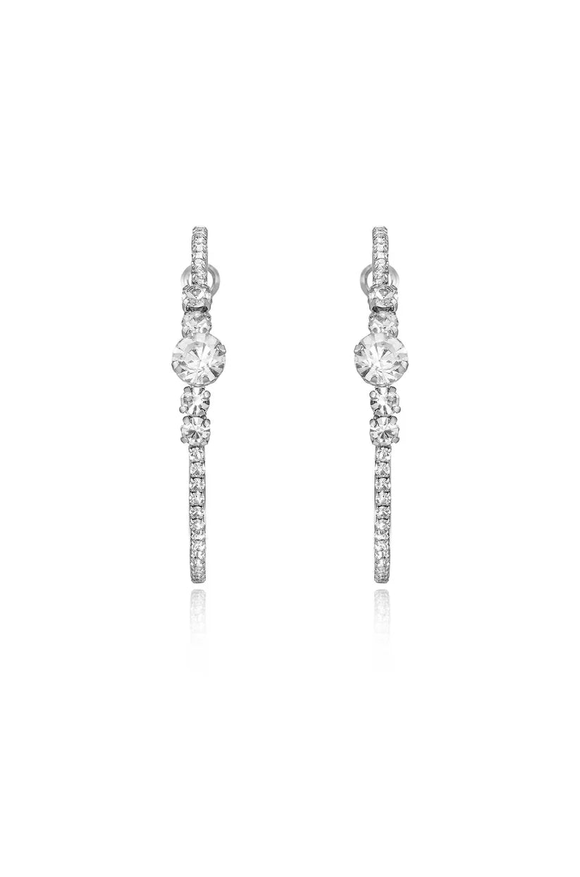A pair of large silver-toned hoop earrings featuring clear crystals stones