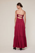 Back view of burgundy corset dress with cutout open back and straps