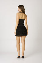 Back view of the Agathe black halter top highlighting the sleek open-back design