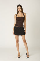 Moeel view of the Agathe brown halter top featuring a wide neckline and ruching 