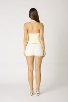 Back view of the Agathe cream halter top highlighting the sleek open-back design