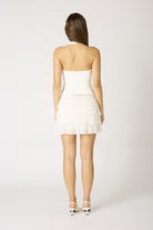 Back view of the Agathe white halter top highlighting the sleek open-back design