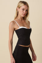 Side profile of the black corset top showing the white contrast peekaboo design