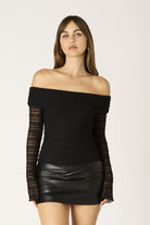 Close-up detail of the floral lace pattern on the Marina black long sleeve top.