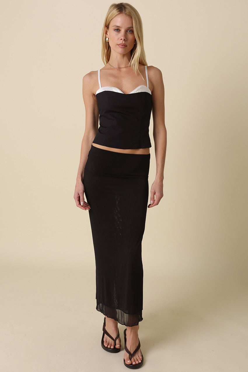 Full body view of the lingerie-inspired Devyn black corset top styled with a black maxi skirt