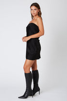 Side profile of a sophisticated black satin strapless dress with a bodycon fit