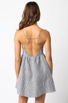 Back view of black striped linen babydoll dress with criss-cross cami straps