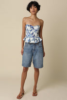Full length front view of the Dani white and blue floral strapless corset top with peplum ruffle hem