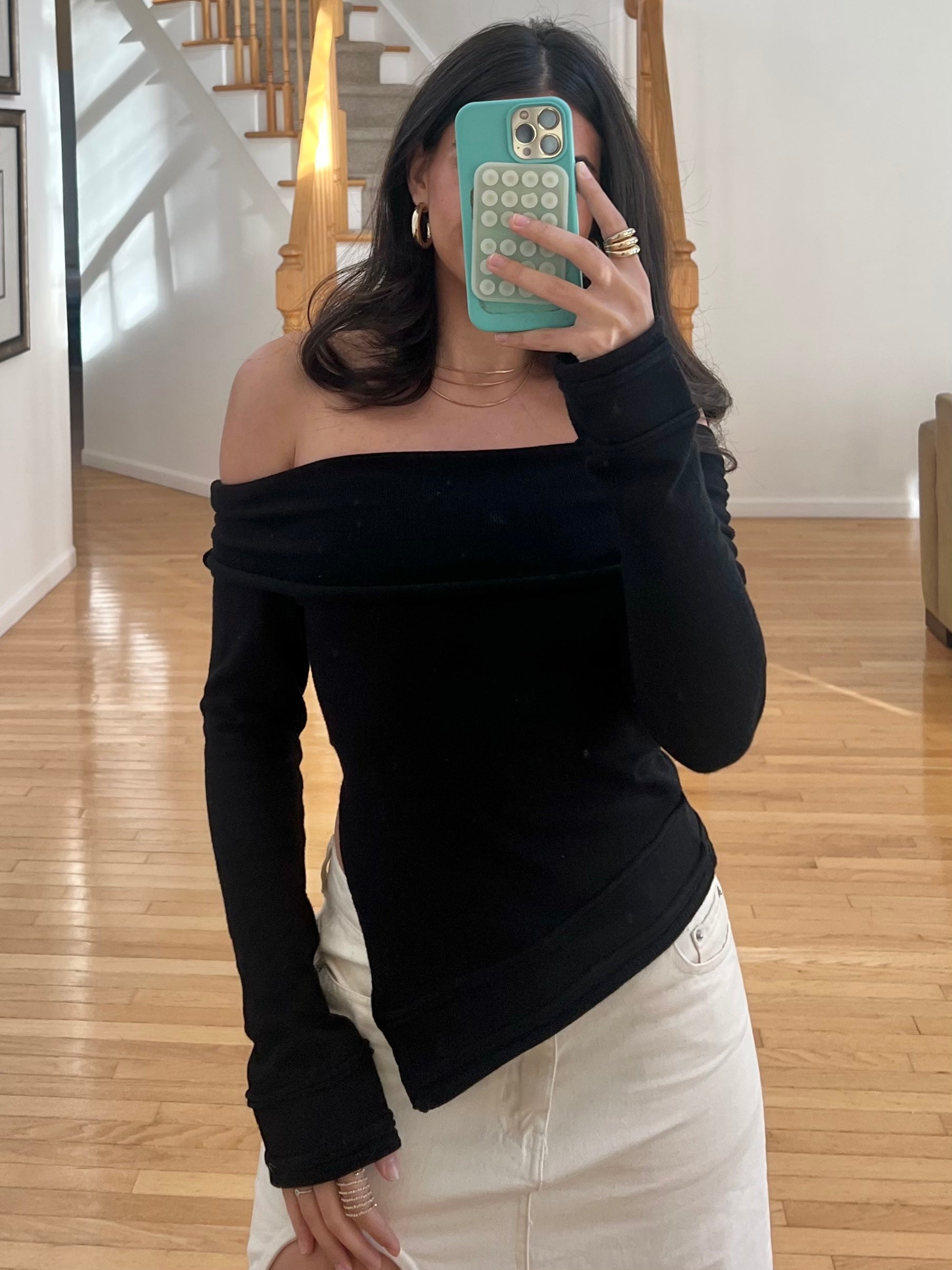 Black asymmetric off-the-shoulder long sleeve top in a cashmere blend knit.