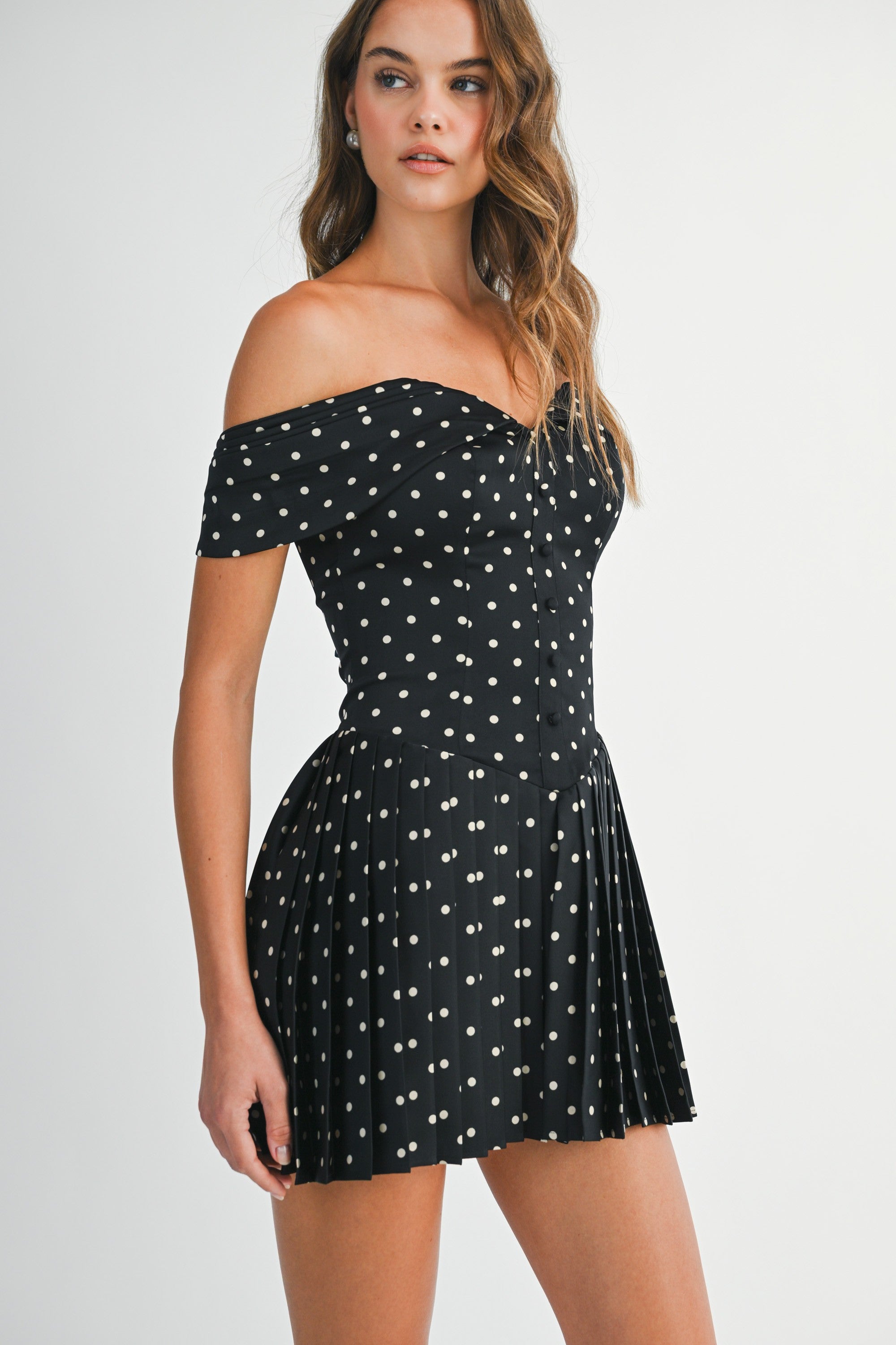Side view of the Elyse mini dress showing the fitted bodice and pleated skirt