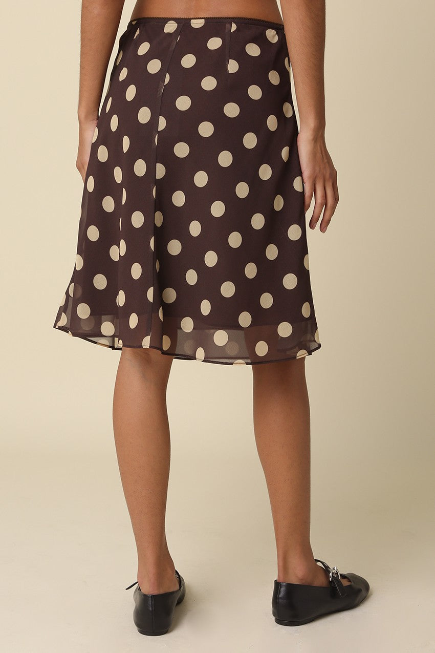 Back view showing the flowy A-line drape of the Emily brown polka dot mesh skirt