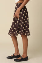 Side view of the Emily midi skirt in chocolate brown with tan polka dots
