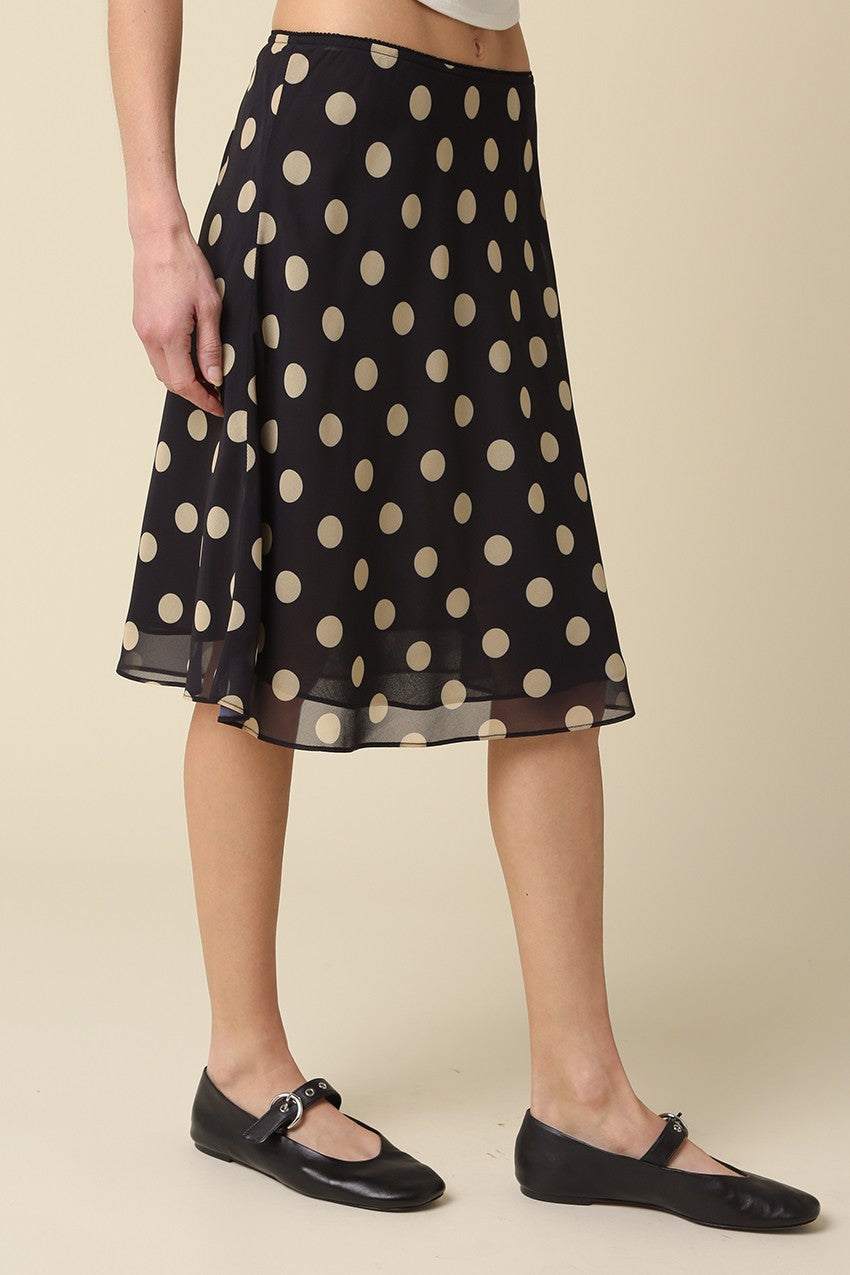 Close-up detail of the sheer layered mesh fabric and classic tan polka dot print