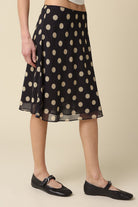 Close-up detail of the sheer layered mesh fabric and classic tan polka dot print
