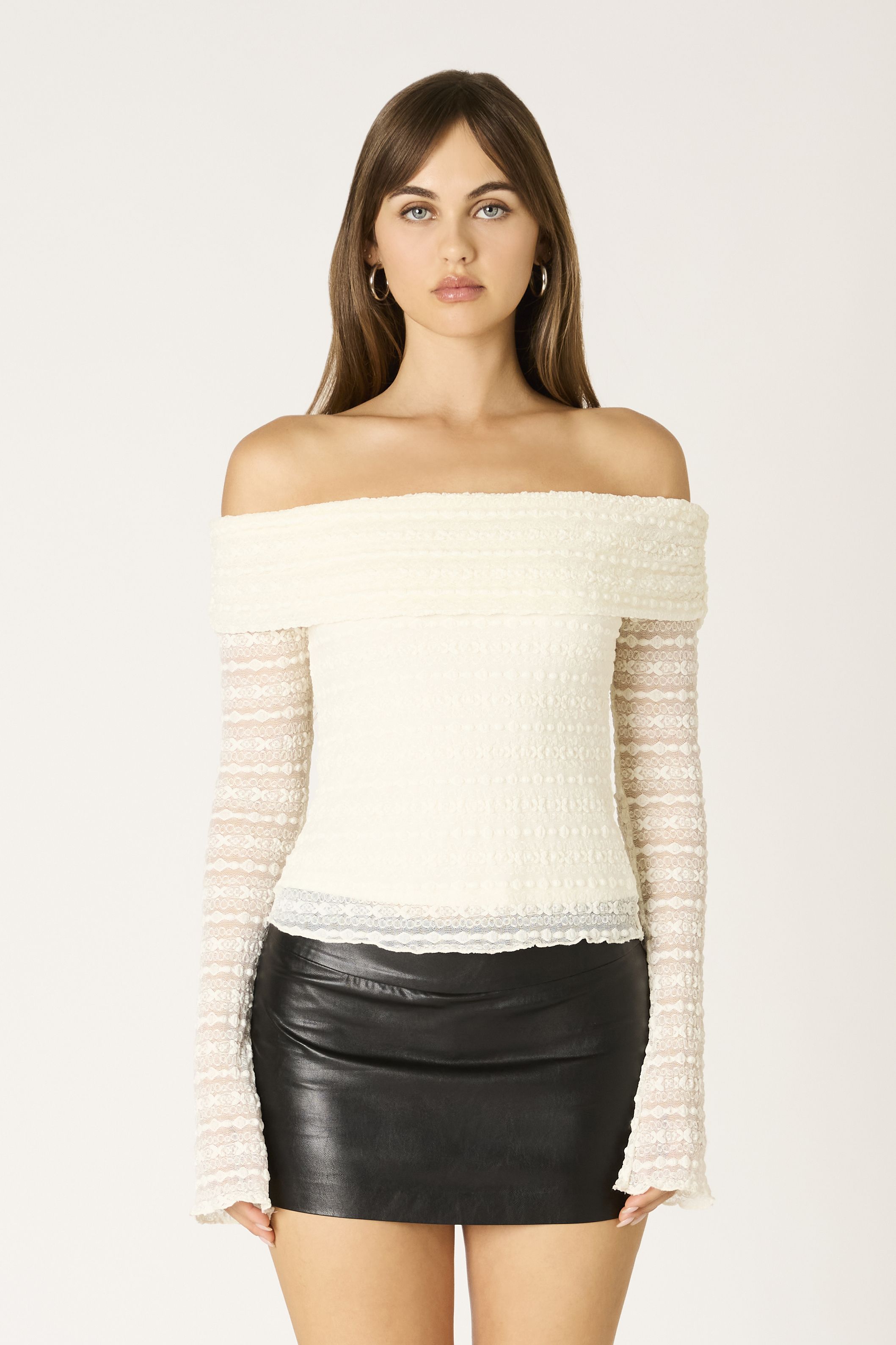Model wearing the ivory lace off-the-shoulder long sleeve top for a resort look
