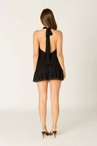 Back view of the black Jenni mini dress with open back detail and halter tie