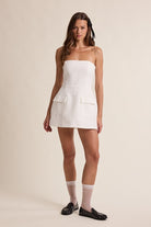 Full-body view of model in the Sky to Moon Lara white strapless romper dress, perfect for a bride-to-be, graduation, or sorority rush