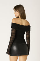 Side profile of the black lace off-the-shoulder top