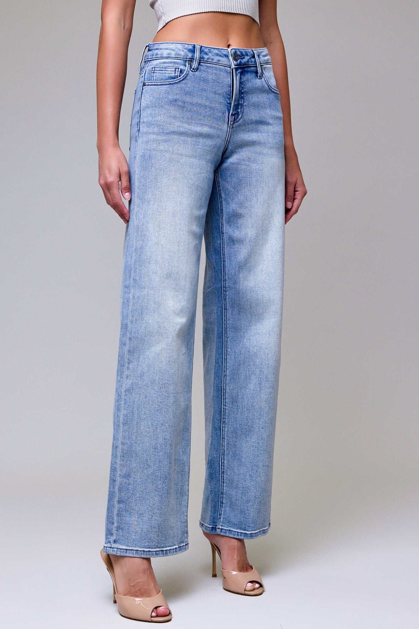 Side view of mid rise light wash dad jeans showing the relaxed fit through the hip and straight wide leg.