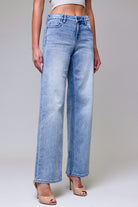Side view of mid rise light wash dad jeans showing the relaxed fit through the hip and straight wide leg.