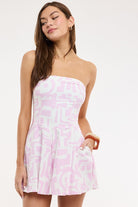 Close-up of a strapless tube-style romper dress in pink and white 