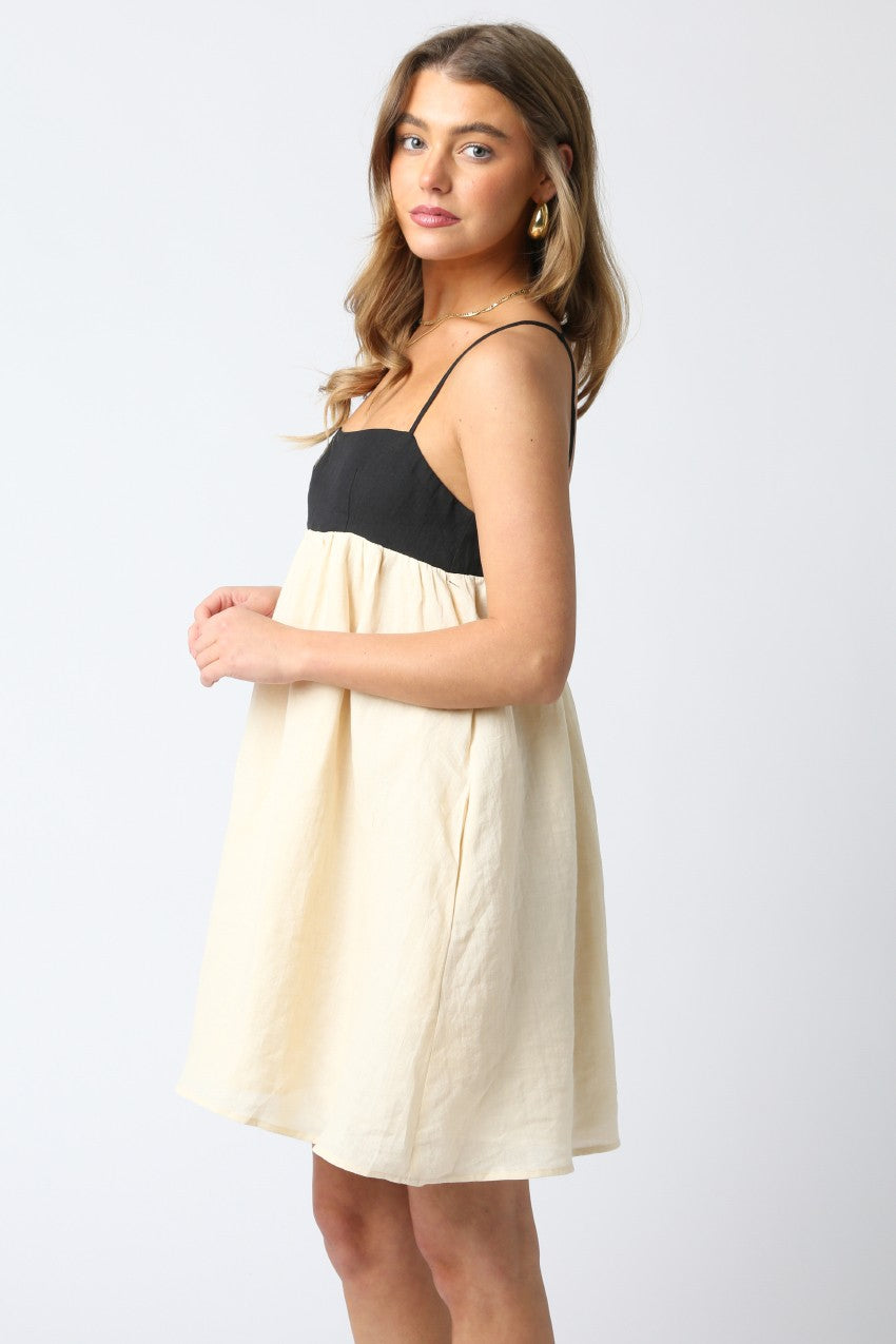 Model wearing a black and cream babydoll dress for sorority rush.