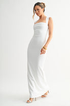 Side profile of a woman in a white floor-length dress with a soft stretch finish