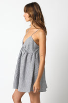 Side view of black striped linen mini dress showing the babydoll silhouette