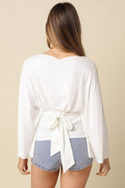 White dolman sleeve top featuring adjustable back tie waist